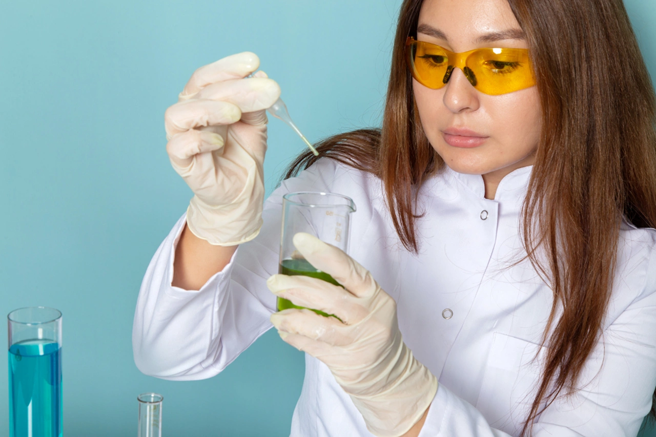 Mulher cientista manipulando solução com alantoína em laboratório