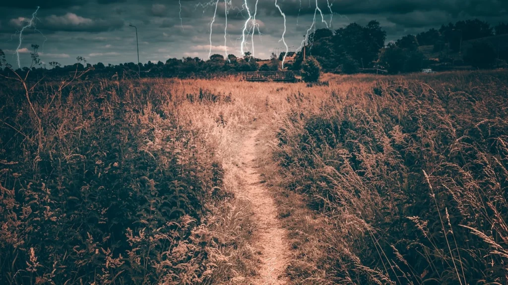 Céu de inverno em Portugal com relâmpagos sobre campo rural, simbolizando riscos climáticos e tempestades sazonais.