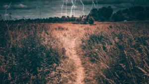 Céu de inverno em Portugal com relâmpagos sobre campo rural, simbolizando riscos climáticos e tempestades sazonais.