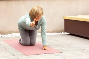Exercício físico aos 40+: mulher a realizar bird-dog no tapete para fortalecer core e estabilidade