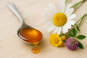 Colher com mel dourado natural ao lado de flores